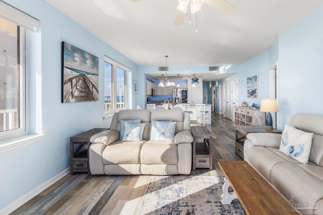 living room featuring wood-type flooring and ceiling fan with notable chandelier