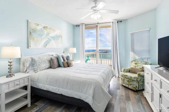 bedroom featuring ceiling fan, access to exterior, dark hardwood / wood-style flooring, and multiple windows