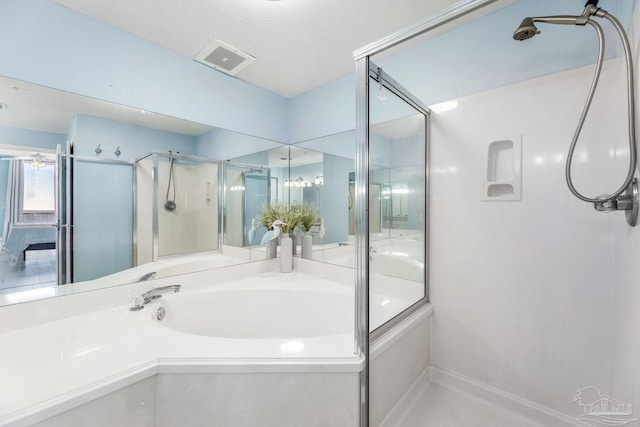 bathroom featuring shower with separate bathtub and a textured ceiling