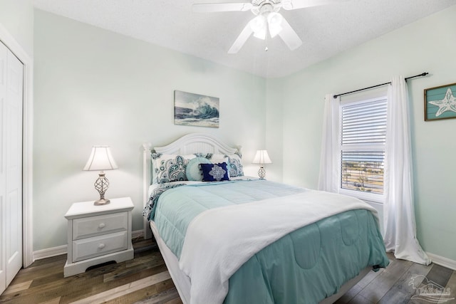 bedroom with dark hardwood / wood-style floors, a textured ceiling, ceiling fan, and a closet