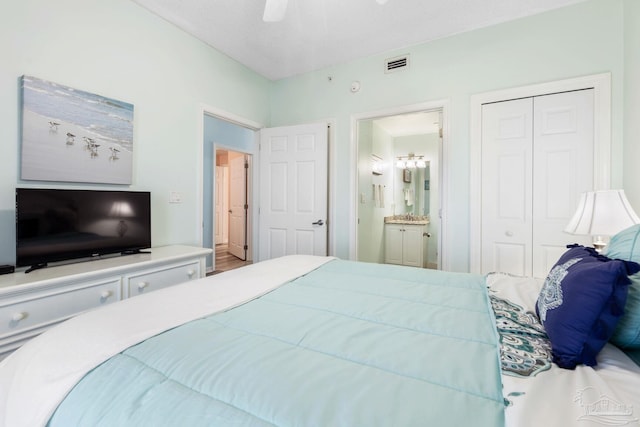 bedroom with ceiling fan, ensuite bathroom, and a closet