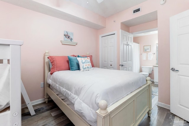 bedroom featuring dark hardwood / wood-style flooring, a closet, and ensuite bathroom