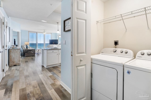 washroom with ceiling fan, light hardwood / wood-style floors, and washing machine and dryer