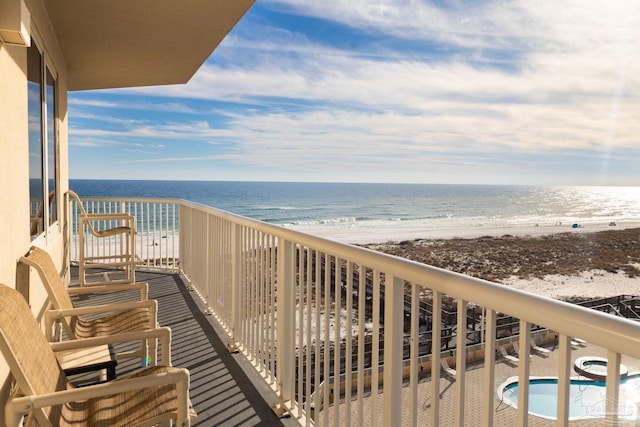 balcony featuring a water view and a view of the beach