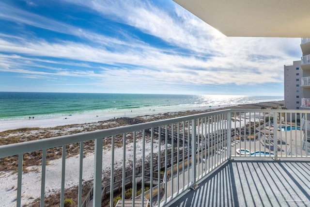 balcony featuring a water view and a beach view