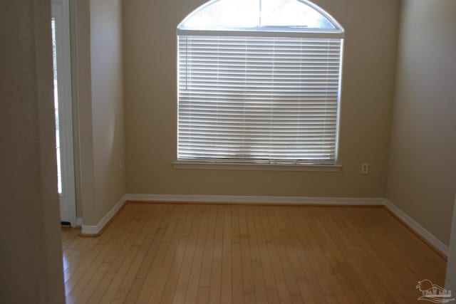 empty room featuring light wood-style flooring and baseboards