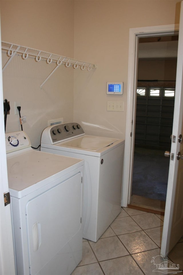 washroom featuring light tile patterned floors, laundry area, and independent washer and dryer