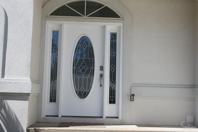 entrance to property with stucco siding