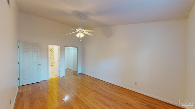 unfurnished bedroom with ceiling fan, ensuite bath, and light wood-type flooring