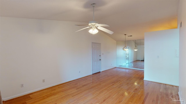 empty room featuring vaulted ceiling, ceiling fan, and light hardwood / wood-style flooring