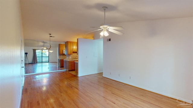 unfurnished living room with ceiling fan and light wood-type flooring