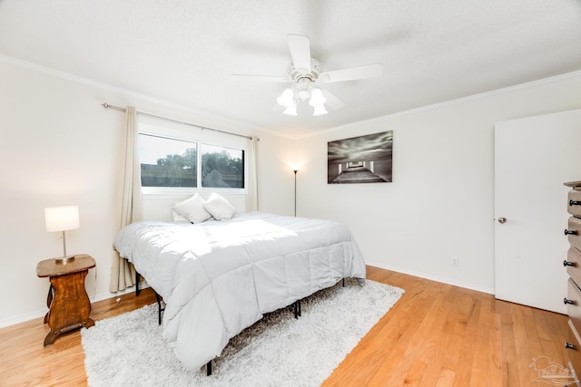 bedroom with hardwood / wood-style floors, ceiling fan, and ornamental molding