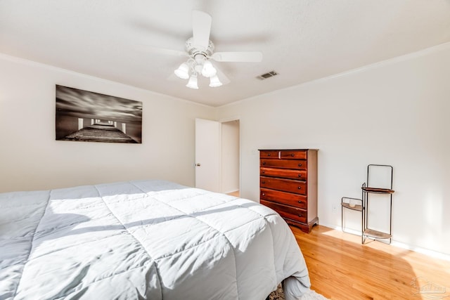 bedroom with hardwood / wood-style flooring, ceiling fan, and ornamental molding