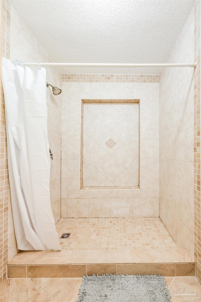 bathroom with tile walls, tile patterned flooring, a textured ceiling, and a shower with shower curtain