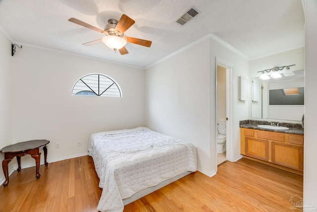 bedroom with ensuite bathroom, ornamental molding, ceiling fan, sink, and light hardwood / wood-style floors