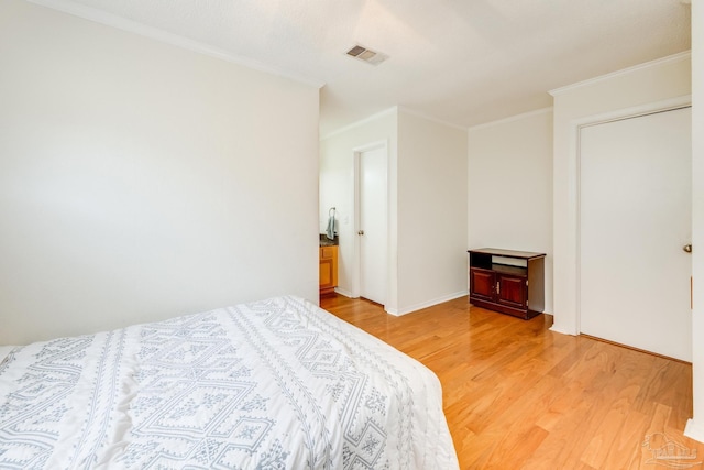 bedroom featuring light wood-type flooring and crown molding