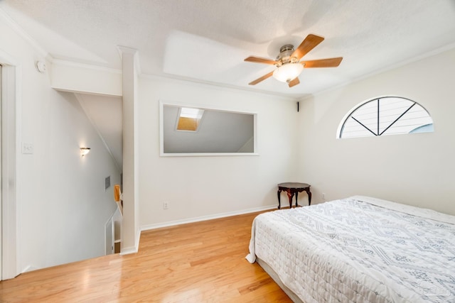 bedroom with hardwood / wood-style flooring, ceiling fan, ornamental molding, and a textured ceiling