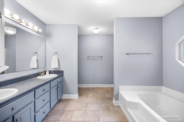 7951 Amethyst Dr, Pensacola, FL 32506 - full bathroom featuring baseboards, a garden tub, double vanity, tile patterned floors, and a textured ceiling