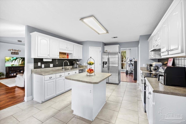 7951 Amethyst Dr, Pensacola, FL 32506 - kitchen featuring appliances with stainless steel finishes, a sink, tasteful backsplash, a kitchen island, and white cabinetry