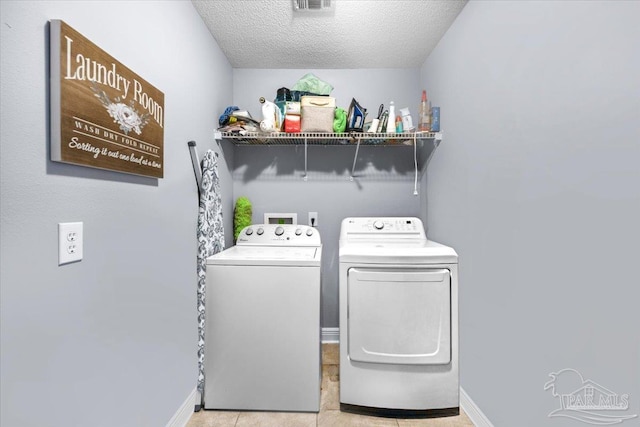 7951 Amethyst Dr, Pensacola, FL 32506 - laundry area with washer and dryer, a textured ceiling, light tile patterned flooring, and baseboards