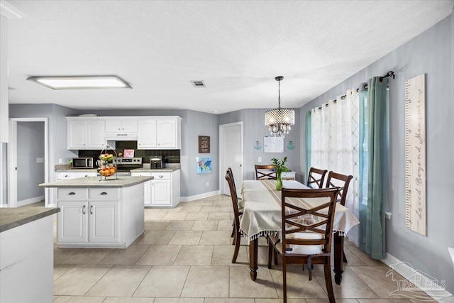 7951 Amethyst Dr, Pensacola, FL 32506 - kitchen featuring stainless steel appliances, white cabinetry, a chandelier, hanging light fixtures, and light tile patterned floors