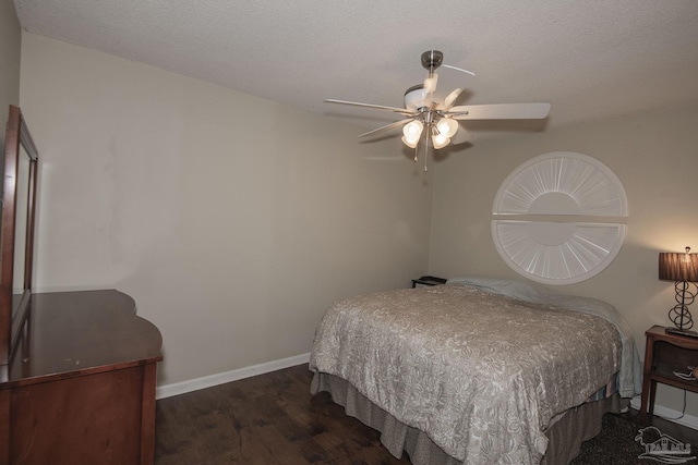 bedroom with ceiling fan, dark hardwood / wood-style floors, and a textured ceiling