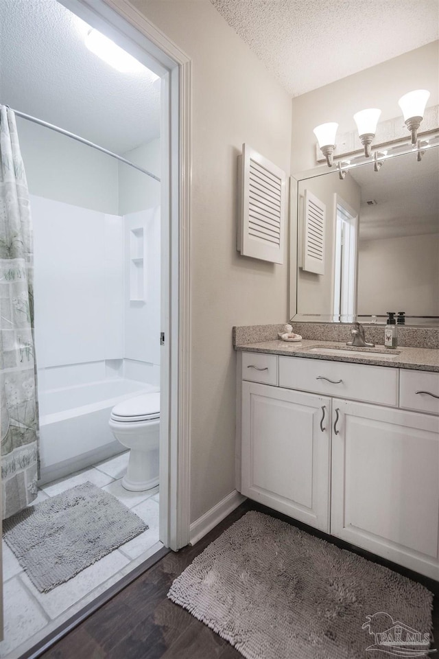 full bathroom featuring shower / tub combo with curtain, wood-type flooring, vanity, toilet, and a textured ceiling