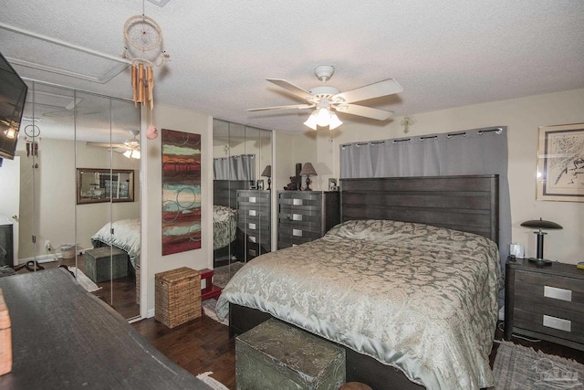 bedroom with ceiling fan, dark hardwood / wood-style floors, and a textured ceiling