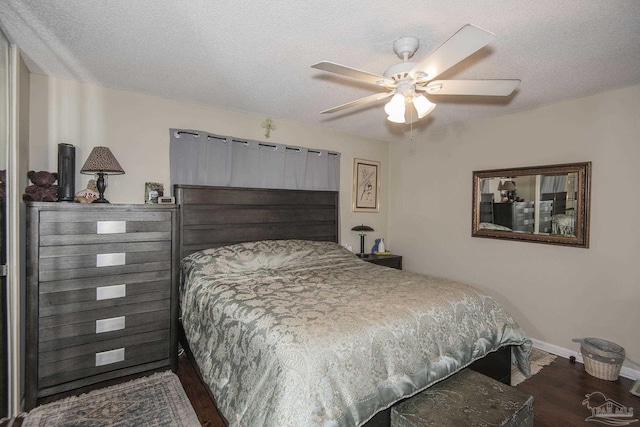 bedroom with ceiling fan, dark hardwood / wood-style floors, and a textured ceiling