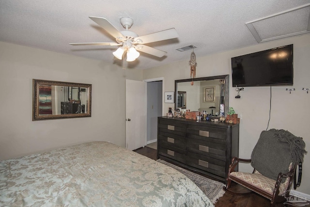 bedroom featuring ceiling fan, hardwood / wood-style floors, and a textured ceiling