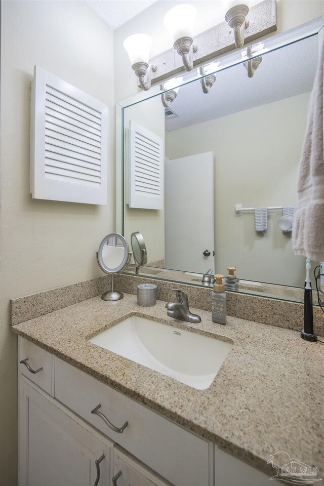 bathroom featuring vanity and a chandelier