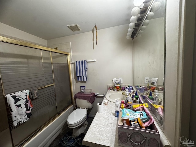 full bathroom featuring vanity, shower / bath combination with glass door, and toilet