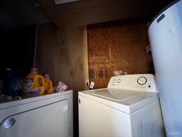 laundry area featuring wooden walls and independent washer and dryer