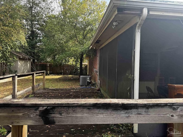 view of property exterior with central AC unit, a storage shed, and a deck