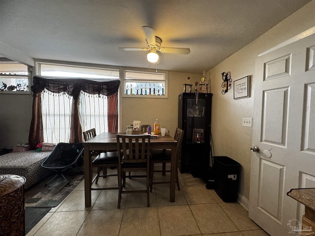 tiled dining space featuring ceiling fan and a textured ceiling