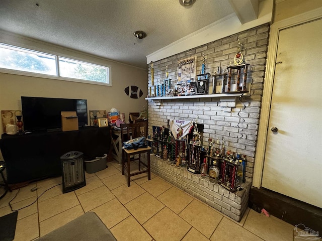 tiled living room featuring ornamental molding, a textured ceiling, and brick wall