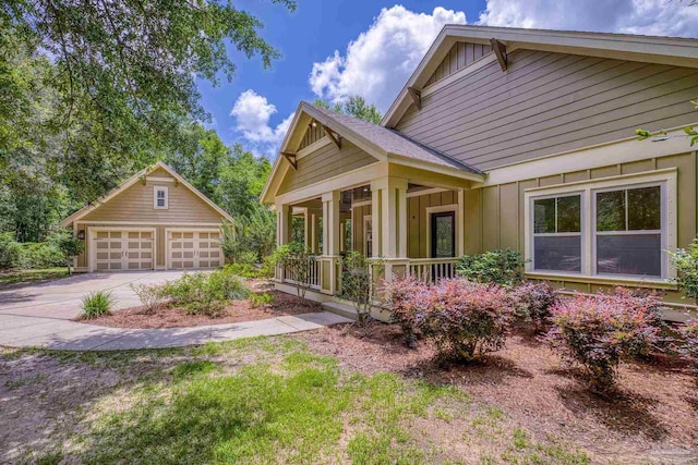 7515 Whiting Acres Ln, Milton, FL 32570 - view of side of home featuring board and batten siding, covered porch, a garage, and an outbuilding