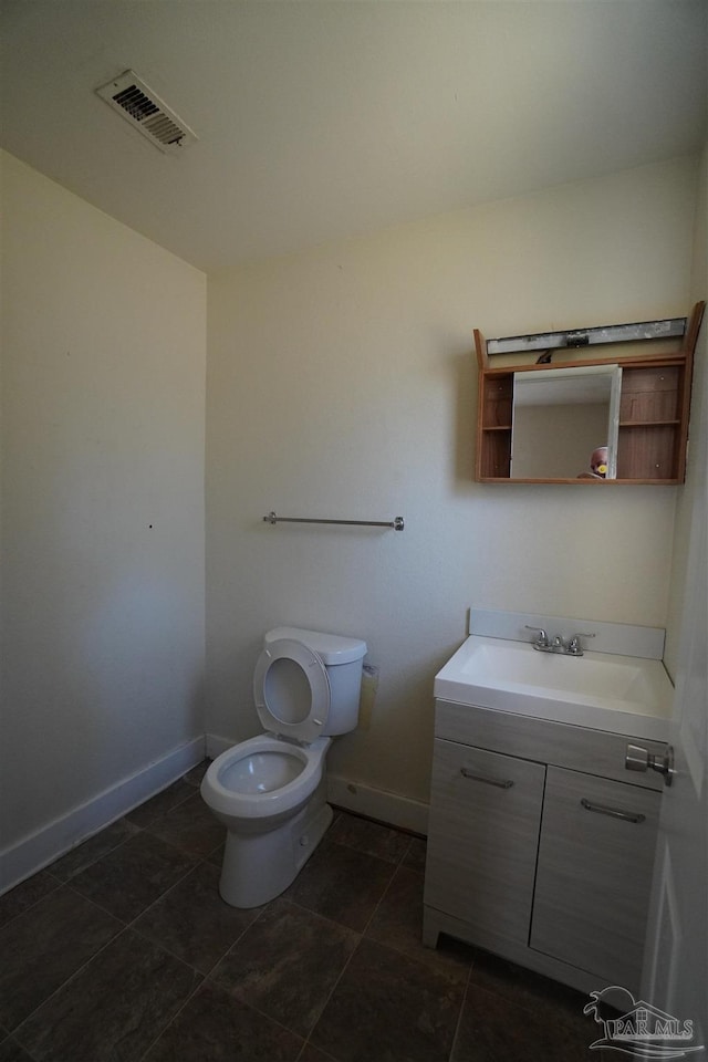 bathroom with vanity, toilet, and tile patterned floors