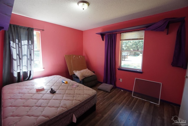 bedroom featuring a textured ceiling and dark hardwood / wood-style flooring