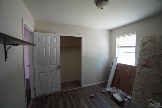 unfurnished bedroom featuring dark wood-type flooring and a closet