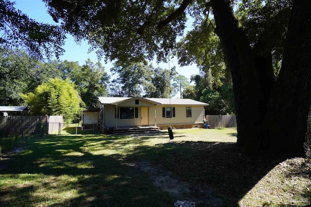 rear view of house featuring a lawn