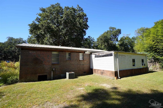 view of home's exterior featuring central air condition unit and a lawn