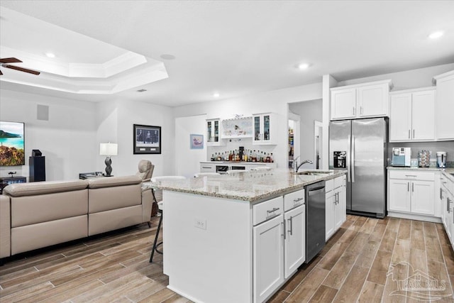 kitchen featuring light wood-style floors, glass insert cabinets, appliances with stainless steel finishes, and open floor plan