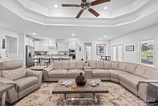 living area with a ceiling fan, recessed lighting, and a raised ceiling