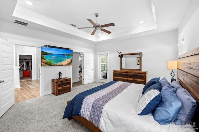 bedroom with carpet flooring, a tray ceiling, visible vents, and recessed lighting