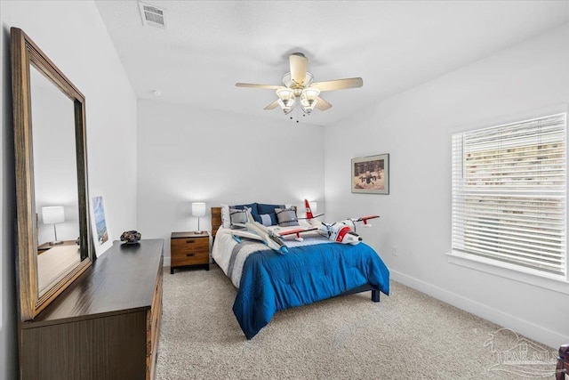 bedroom with baseboards, a ceiling fan, visible vents, and carpet