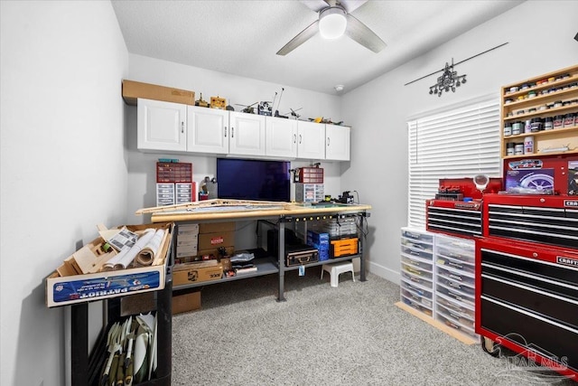carpeted office with a ceiling fan