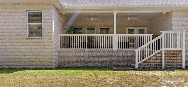 exterior space featuring brick siding, a ceiling fan, and a lawn