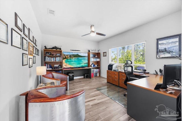 office featuring baseboards, wood finished floors, visible vents, and ceiling fan