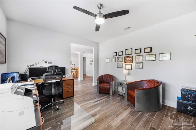 office space featuring wood finished floors, visible vents, baseboards, and ceiling fan
